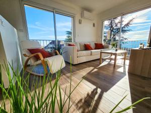 ein Wohnzimmer mit einer Couch und einigen Fenstern in der Unterkunft Maison - Saint-Martin La Plaine - Loire in Saint-Martin-la-Plaine