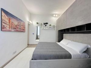 una camera da letto con un letto grande in una stanza bianca di Mondo House a Bologna