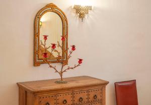 a table with a mirror and a vase with flowers on it at Casa d'Aldeia in Rio Maior +12 photos