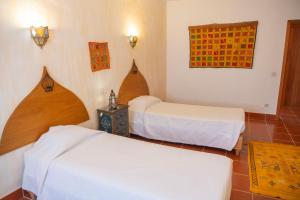 a hotel room with two beds and a window at Casa d'Aldeia in Rio Maior