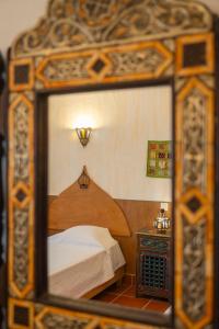 a reflection of a bedroom with a bed in a mirror at Casa d'Aldeia in Rio Maior