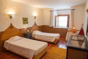 a hotel room with two beds and a window at Casa d'Aldeia in Rio Maior
