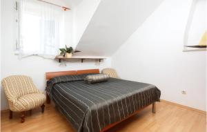 Beautiful Apartment In Bol With Wifi في بول: غرفة نوم بها سرير وكرسيين