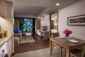 a kitchen and living room with a table and a dining room at Citadines Grand Central Sri Racha in Si Racha