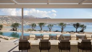 eine Terrasse mit Stühlen und einem Pool mit Aussicht in der Unterkunft Kenshō Paros in Krotiri