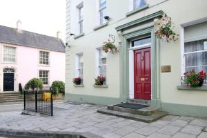 una puerta roja al lado de una casa blanca en Charlemont House, en Dungannon