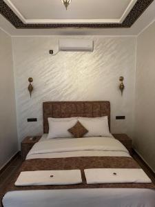 sypialnia z dużym łóżkiem i dwiema poduszkami w obiekcie Marrakech to desert camp w mieście Merzouga
