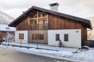 un bâtiment avec un arbre de Noël devant lui dans l'établissement AO HOUSE - Chalet PAN BENA, aux Houches
