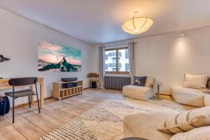 un salon avec un canapé et une chaise dans l'établissement AO HOUSE - Chalet PAN BENA, aux Houches