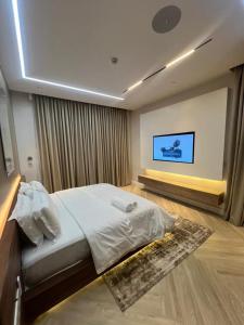 una camera da letto con un letto e una TV a parete di Chizzly Apartment a Bamgbose