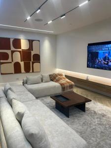 un soggiorno con divano e TV a schermo piatto di Chizzly Apartment a Bamgbose