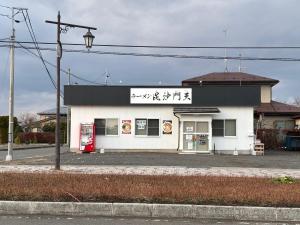 a white building with writing on the side of it at Rental House Towada Yuzuriha Gallery Stay City in Towada
