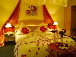 a bedroom with a large bed with red flowers on it at Hotel Schoch in Mainhardt