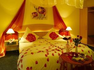 una camera da letto con un grande letto con fiori rossi di Hotel Schoch a Mainhardt