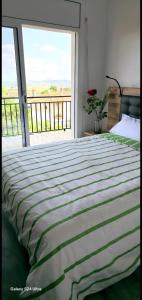 een groot bed in een slaapkamer met een groot raam bij Casa con mucha luz natural in Bisbal del Penedès