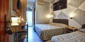 a hotel room with two beds in a room at Hotel Riz in Cesenatico