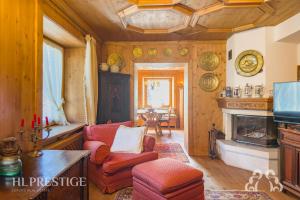 un soggiorno con divano e camino di Suite Villa Francesca a Cortina dʼAmpezzo