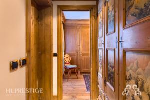 un corridoio con porta in legno e sedia di Suite Villa Francesca a Cortina dʼAmpezzo