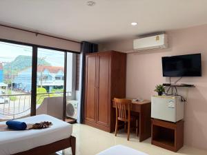 um quarto de hotel com uma cama, uma escrivaninha e uma televisão em Mookanda Residence em Praia de Ao Nang mais 49 fotografias