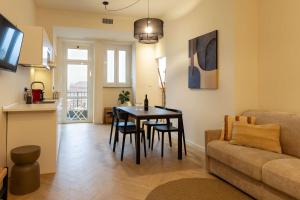 ein Wohnzimmer mit Tisch und Couch in der Unterkunft Domus Nova - Una finestra sui tetti in Turin