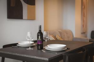 ein Tisch mit einer Flasche Wein und zwei Gläsern in der Unterkunft Domus Nova - Una finestra sui tetti in Turin