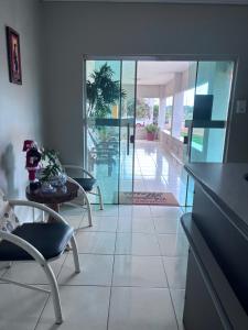 a living room with a table and chairs and a glass door at Pousada Chapada das Mesas in Riachão