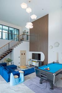 een woonkamer met een pooltafel en een trap bij About P พูลวิลล่า ชะอำ in Ban Phu Wai