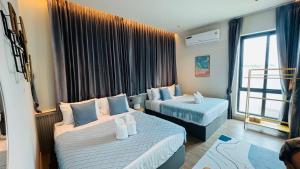 een hotelkamer met twee bedden en een raam bij About P พูลวิลล่า ชะอำ in Ban Phu Wai +21 foto's