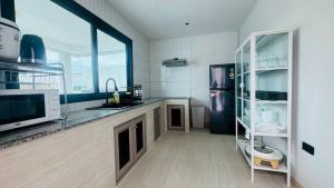 een keuken met een spoelbak en een koelkast bij About P พูลวิลล่า ชะอำ in Ban Phu Wai