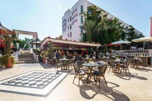 Un patio al aire libre con mesas y sillas frente a un edificio. en Club Hotel Sera, en Antalya