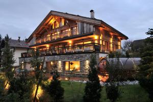 a large wooden house with lights on it at Chalet Enigma in La Clusaz