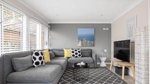 Pretty BeachNumber 96 At Pretty Beach By Holidayco的客厅里有一张灰色沙发和一台电视