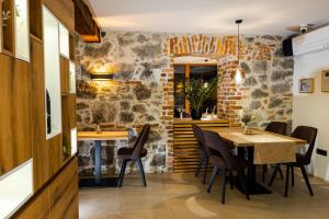 una sala da pranzo con parete in pietra, tavolo e sedie di Resort Village Majer - Bela krajina a Gradac