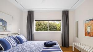 Pretty BeachNumber 96 At Pretty Beach By Holidayco的一间卧室，配有一张带蓝色枕头的床和一扇窗户 更多16张照片