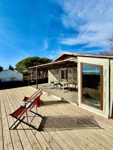 a wooden deck with a bench and a house at La Cabane du Pêcheur, Clim et bord d'étang! in Pérols