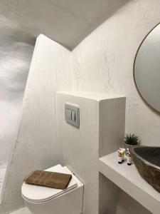 Petuna Cave Suites في فيرا: حمام أبيض مع مرحاض ومغسلة +14 صورة