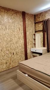 een slaapkamer met een bed, een bureau en een muur bij Baan Chok Dee Homestay in Chiang Khan +6 foto's