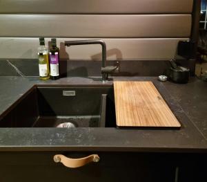 a kitchen counter with a sink and a wooden cutting board at Family Cabin With Stunning Views At Sjusjøen in Eggedal +32 photos