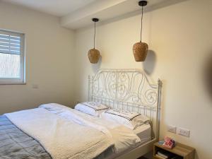 Gonenにあるשלווה בנוף העמקの白いベッドと枕が2つある寝室