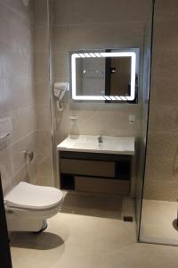 a bathroom with a toilet and a sink and a mirror at El Fares Hôtel Spa & Conférences in Bordj Bou Arreridj