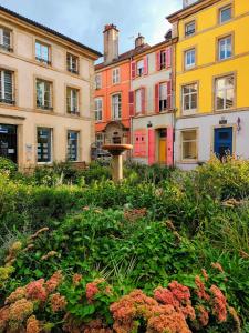 um jardim em frente aos prédios com um bebedouro para pássaros em Les Bulles B&B em Épinal