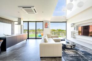 Una sala de estar con un sofá blanco y una mesa. en Ocean Villa Fuchaku Okinawa, en Fuzuchi