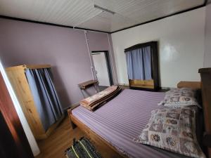 een slaapkamer met een bed en twee ramen bij Chez Lalie in Mandriankeniheny