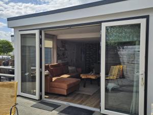 a sliding glass door of a living room with a couch at Chalet 138 lodge in Sint Annaland