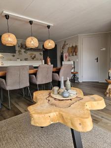 a living room with a wooden table and a dining room at Chalet 138 lodge in Sint Annaland +34 photos