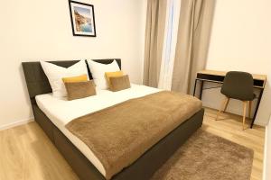 1 dormitorio con cama con almohadas y escritorio en Stadtwohnung in Siegen-Zentrum, en Siegen