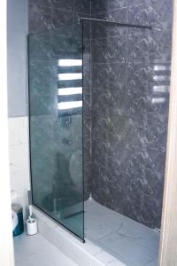 a shower with a glass door in a bathroom at House 32 Hotels and Suites in Lagos