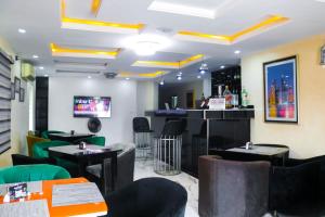a restaurant with tables and chairs and a bar at House 32 Hotels and Suites in Lagos