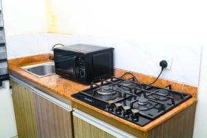 a microwave sitting on top of a stove in a kitchen at House 32 Hotels and Suites in Lagos +30 photos