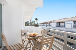 a table and chairs on a balcony with a train at Apartaments S'Estanyol in La Savina